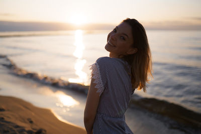 Beautiful young woman on beach during sunset