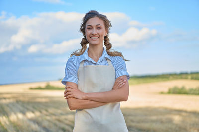 Portrait of a smiling young woman standing on field