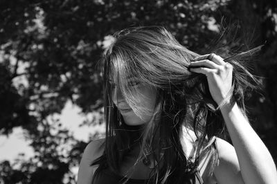 Close-up of young woman with hand in hair