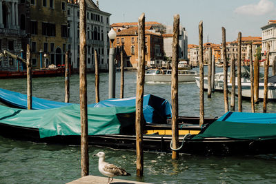 Boats moored in canal by buildings in city venice italy