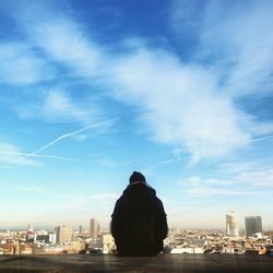 Rear view of person overlooking cityscape