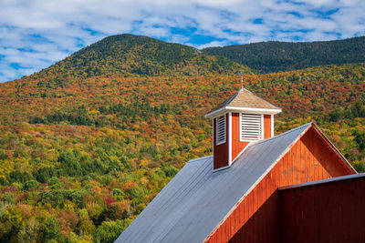 House by mountain against sky