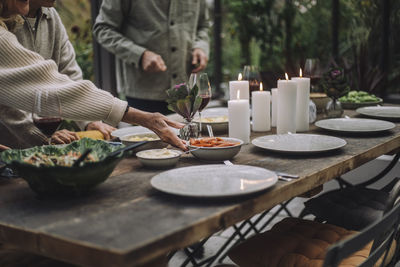 Hand of senior woman preparing dining table for party