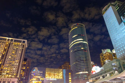 Low angle view of illuminated buildings against sky at night