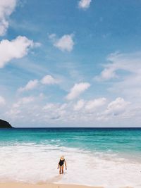 Woman at beach against sky