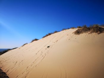 Scenic view of desert against clear blue sky