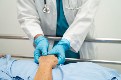 Midsection of doctor examining patient in hospital