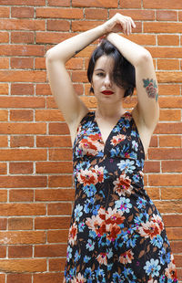 Young woman standing against wall