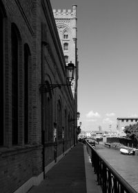 Footpath amidst buildings against sky