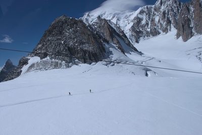 People skiing on snowcapped mountain against sky