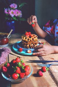 High angle view of woman holding fruits on table