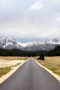 Road amidst field against sky