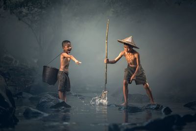 Full length of shirtless boy standing in sea