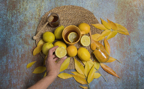 Directly above shot of hand holding lemon in basket