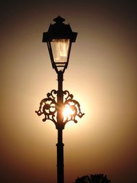 Low angle view of illuminated street light against sky during sunset