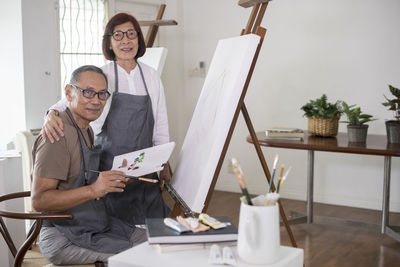 Man and woman using phone while sitting on table