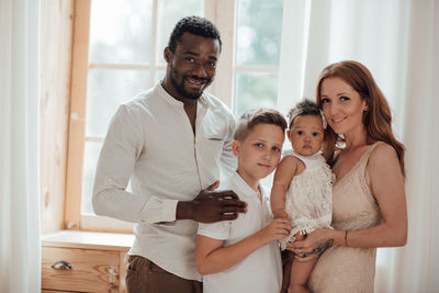 Portrait of a smiling young woman standing at home