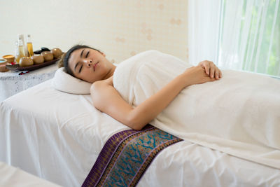 Young woman lying on massage table in spa