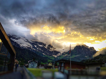 Scenic view of mountains against cloudy sky at sunset