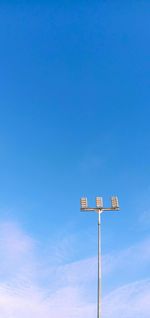 Low angle view of telephone pole against blue sky