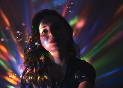 Portrait of woman in illuminated nightclub