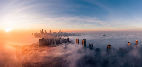 Aerial view of buildings in city during sunset