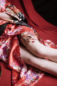 An asian girl in japanese geisha, tattoos on her legs. asian style tattoo. red geisha