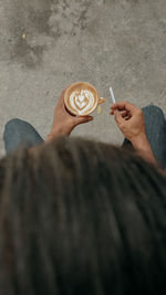 High angle view of men holding cappucino