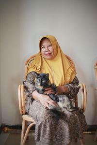 Portrait of young woman sitting on sofa at home