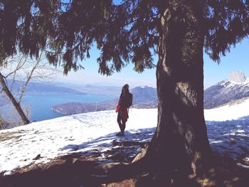 Rear view of woman standing on snow covered landscape