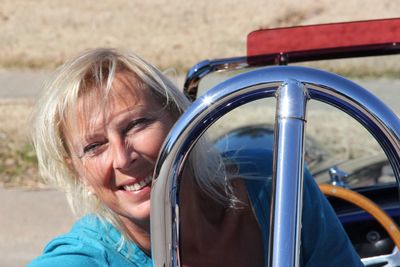 Close-up portrait of smiling mature woman in car