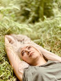 Portrait of young woman lying on grass