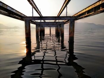 Pier on bridge over river against sky