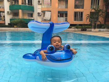 Portrait of happy boy playing in swimming pool