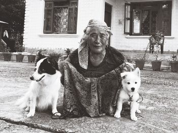 Portrait of senior woman with dogs crouching outdoors