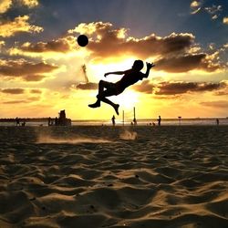 People enjoying at beach during sunset