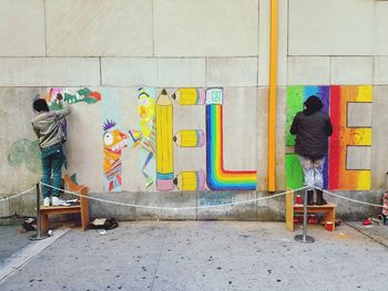 Man standing against multi colored wall