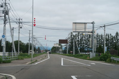 Vehicles on road against sky in city