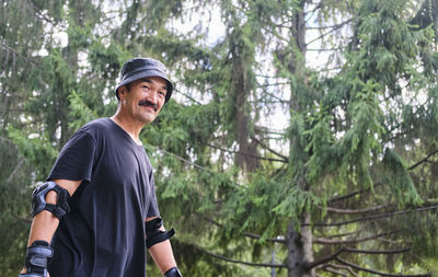 Active senior asian smiling man  with protection on his arms doing sport