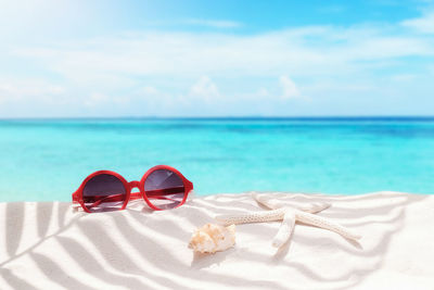 Close-up of sunglasses on beach