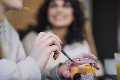 Woman eating fruit dessert in cafe