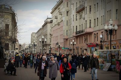 People walking on road amidst buildings in city