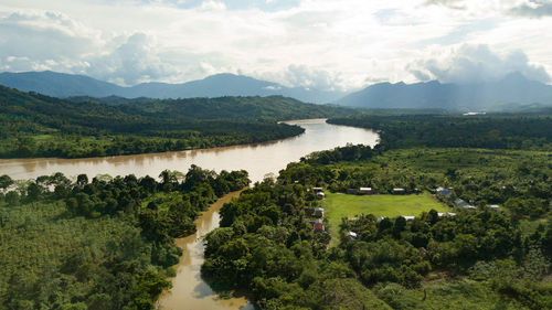 Scenic view of green landscape and mountains against sky