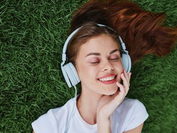 High angle view of young woman sitting on grassy field