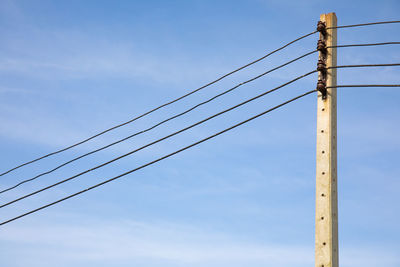 Low angle view of power lines against sky