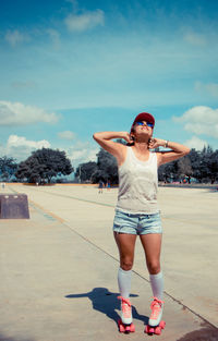 Full length of young woman standing against trees