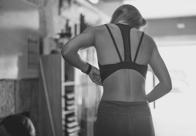 Rear view of woman standing against wall