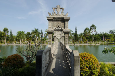 View of statue by lake against sky