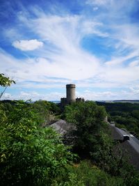 Built structure by plants against sky