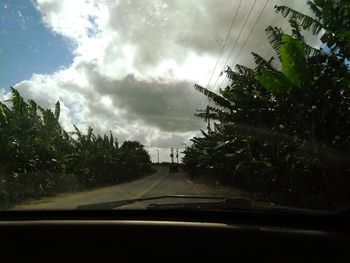 Road seen through car windshield during rainy season